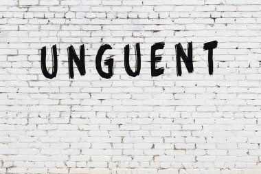 Beyaz tuğla duvara siyah boya ile yazılmış merhem..