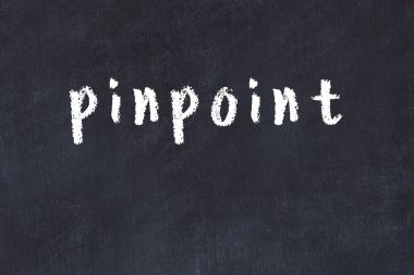 Tebeşir elle yazılmış yazıtlar siyah masanın üzerinde.