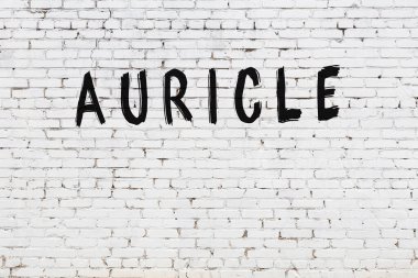 Beyaz tuğla duvara siyah boya ile yazılan yazıtlar..