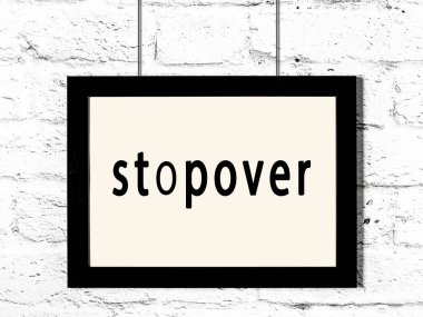 Beyaz tuğla duvarda asılı duran siyah ahşap çerçeve 