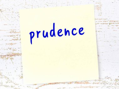 Tedbirli olmayı hatırlatma anlayışı. Tahta duvarda üzerinde yazı olan sarı yapışkan kağıt.