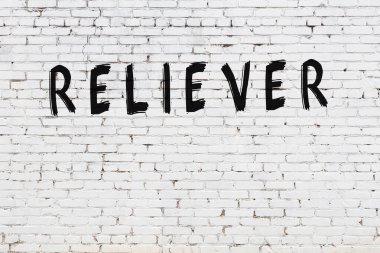 Beyaz tuğla duvara siyah boya ile yazılmış bir yazıt çözücü..