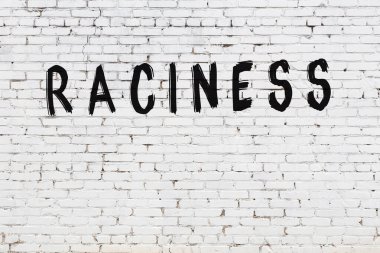 Beyaz tuğlalı duvar, siyah boyayla yazılmış müstehcen yazılar.