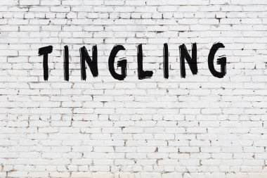 Yazılı beyaz tuğla duvar, el yazısıyla siyah boya.