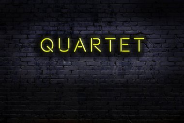 Duvara yazı dörtlüsü çizilmiş neon tabela. Gece görünümü