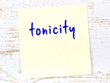 Tahta duvarda el yazısı tonikle yazılmış sarı yapışkan bir not var.