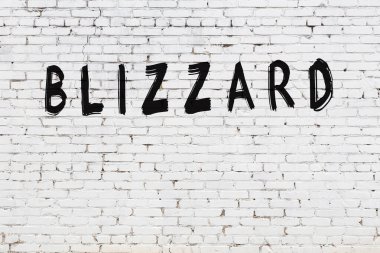 Yazılı beyaz tuğla duvar. Siyah boyayla yazılmış kar fırtınası.