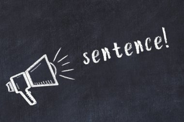 Hoparlörün tebeşir çizimi ve siyah masanın üzerine el yazısıyla yazılmış yazı cümlesi