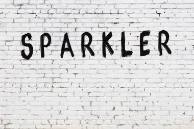 Beyaz tuğlalı duvar. Siyah boyayla yazılmış maytap.