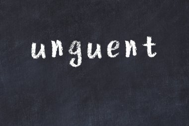 Tebeşir el yazısıyla yazılmış merhem siyah masada.