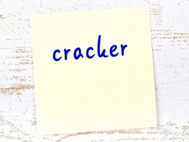 Tahta duvardaki sarı yapışkan notta el yazısıyla yazılmış kraker var.