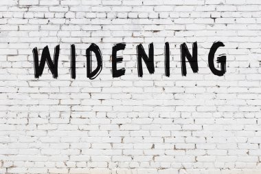 Yazı, beyaz tuğla duvara siyah boya ile yazılmış..