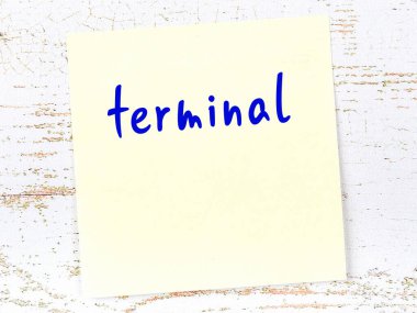 Tahta duvarda el yazısıyla yazılmış, sarı yapışkan bir not var.