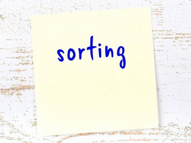 Sıralama hakkında hatırlatma kavramı. Tahta duvarda üzerinde yazı olan sarı yapışkan kağıt.