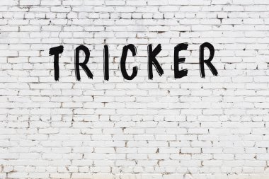 Beyaz tuğlalı duvar, siyah boyalı el yazısı.