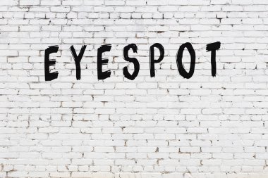 Üzerinde siyah boya bulunan beyaz tuğlalı bir duvar.