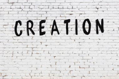 Siyah boyayla el yazısıyla yazılmış beyaz tuğla duvar.