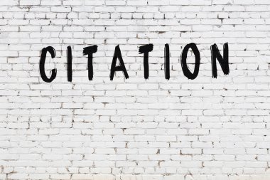 Beyaz tuğla duvara siyah boya ile yazılmış bir yazı..