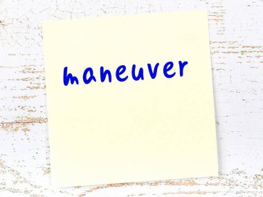 Manevra hakkında hatırlatma kavramı. Tahta duvarda üzerinde yazı olan sarı yapışkan kağıt.