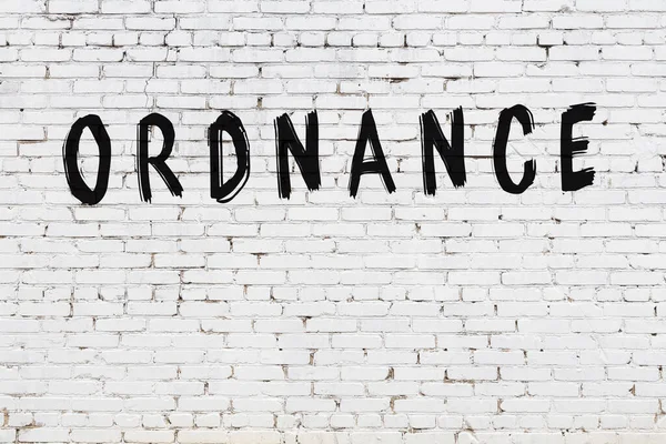 Siyah boyayla el yazısıyla yazılmış beyaz tuğlalı bir duvar.