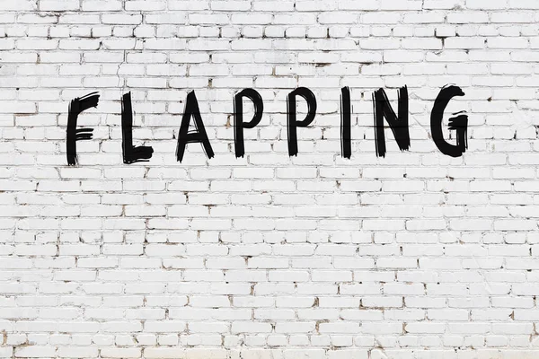 Yazı, beyaz tuğla duvara siyah boya ile yazılmış..