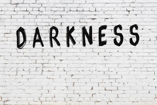 Yazı karanlığı beyaz duvarda siyah boya ile yazılmış..