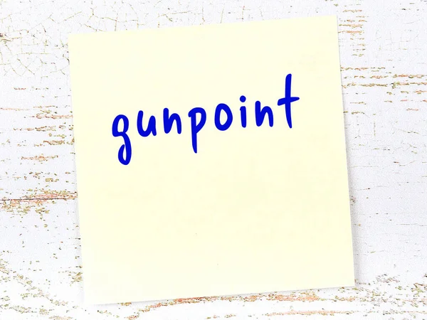 Tahta duvardaki sarı yapışkan notta el yazısıyla yazılmış silah ucu var.