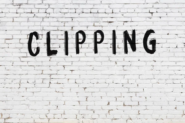 Yazılı beyaz tuğla duvar. Siyah boyayla yazılmış.