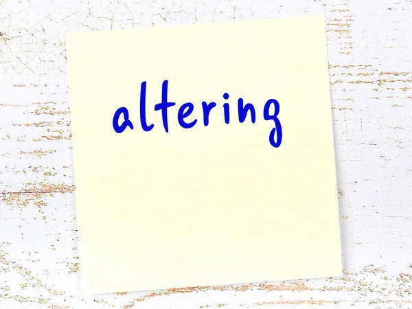 Değişiklik hakkında hatırlatma kavramı. Tahta duvarda üzerinde yazı olan sarı yapışkan kağıt.