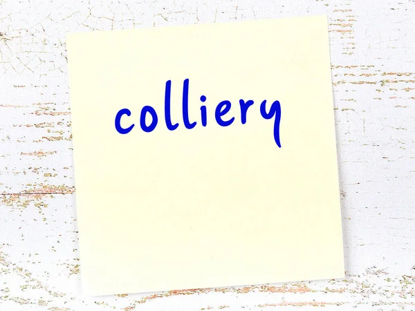 Tahta duvardaki sarı yapışkan notta el yazısı kömür madeni var.