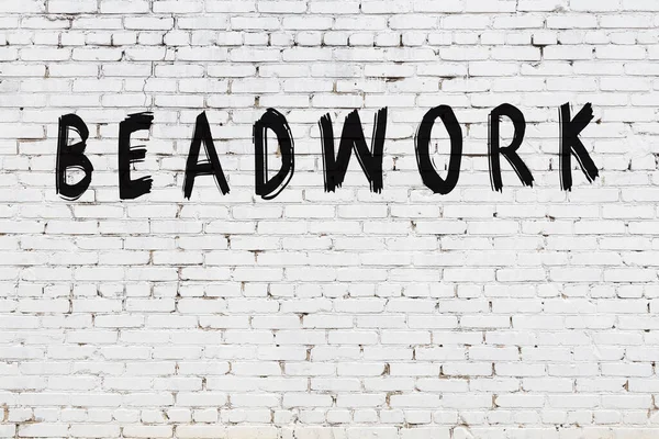 Beyaz tuğla duvara siyah boya ile yazılmış boncuk yazıları..