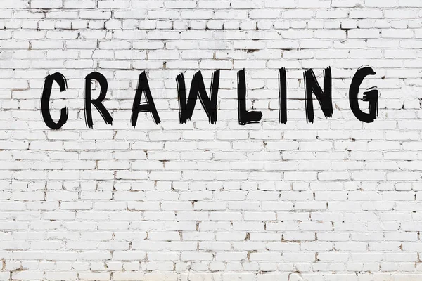 Üzerinde siyah boya yazan beyaz tuğla bir duvar.