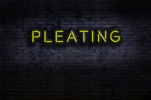 Duvara asılmış, üzerinde yazı olan neon tabela. Gece görünümü