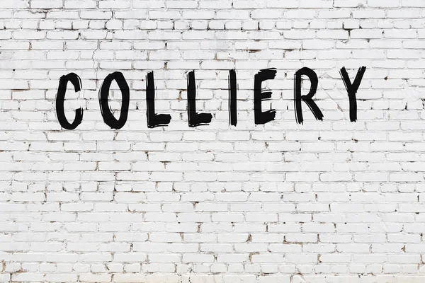 Yazıt kömürü beyaz tuğla duvara siyah boya ile yazılmış..