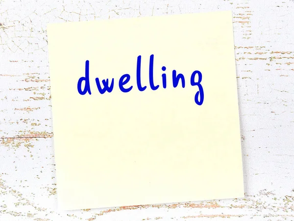 Konut hakkında hatırlatma kavramı. Tahta duvarda üzerinde yazı olan sarı yapışkan kağıt.