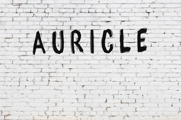 Beyaz tuğla duvara siyah boya ile yazılan yazıtlar..