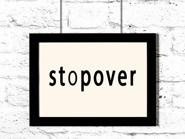 Beyaz tuğla duvarda asılı duran siyah ahşap çerçeve 