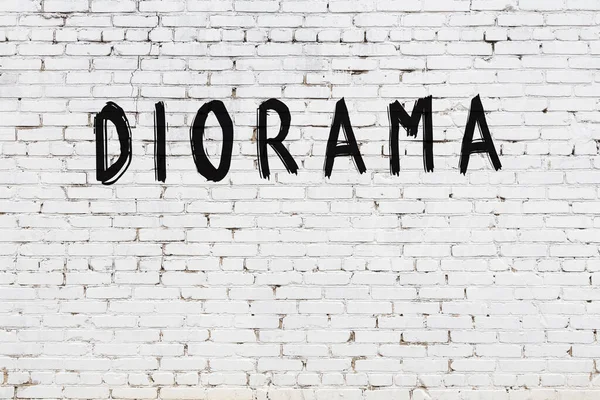 Siyah boyalı el yazısıyla yazması diyorama olan beyaz tuğla duvar.