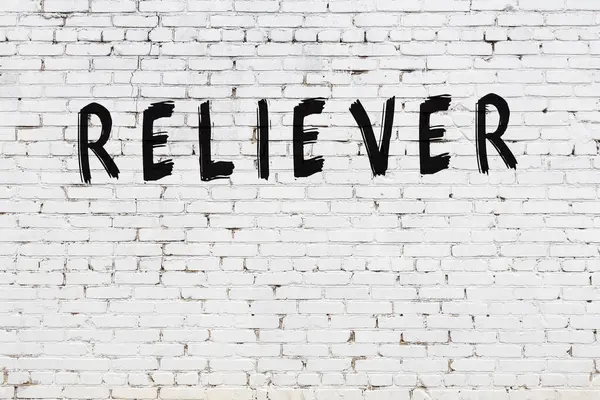 Beyaz tuğla duvara siyah boya ile yazılmış bir yazıt çözücü..