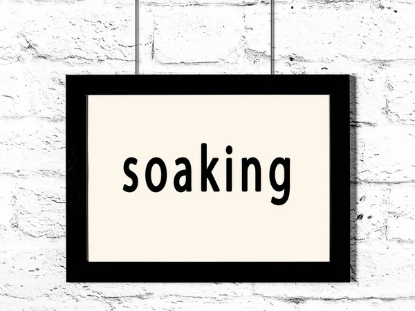 Beyaz tuğla duvara asılı siyah ahşap çerçeve. 