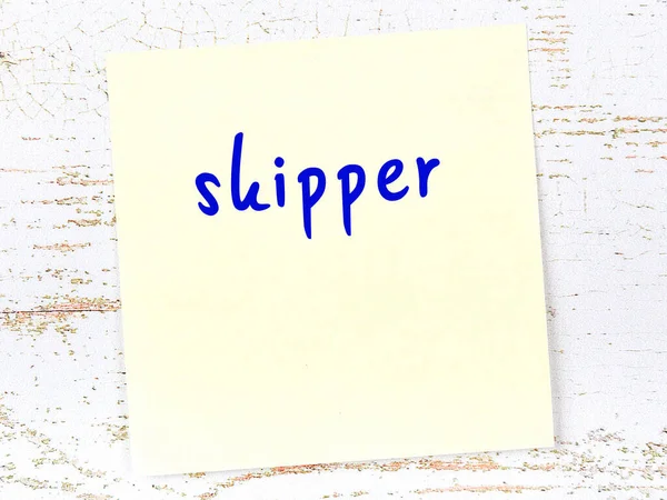 Kaptan hakkında hatırlatma konsepti. Tahta duvarda üzerinde yazı olan sarı yapışkan kağıt.