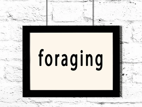 Üzerinde yazı olan siyah ahşap çerçeve beyaz tuğla duvarda asılı. 