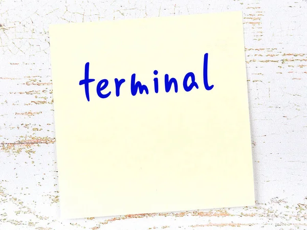 Tahta duvarda el yazısıyla yazılmış, sarı yapışkan bir not var.