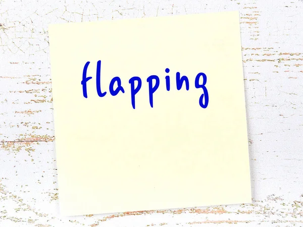 Kanat çırpmayla ilgili hatırlatma kavramı. Tahta duvarda üzerinde yazı olan sarı yapışkan kağıt.