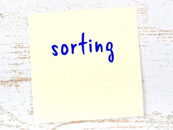 Sıralama hakkında hatırlatma kavramı. Tahta duvarda üzerinde yazı olan sarı yapışkan kağıt.