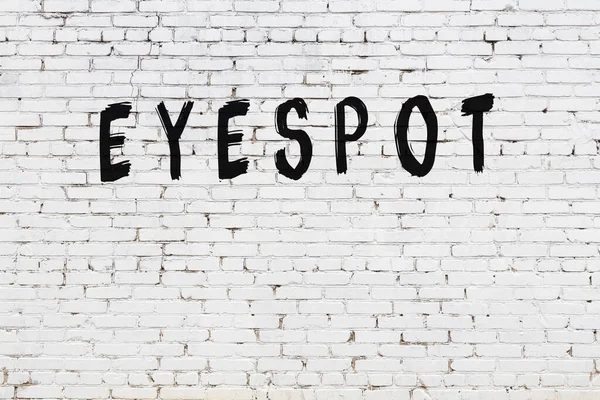 Üzerinde siyah boya bulunan beyaz tuğlalı bir duvar.