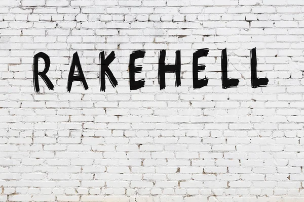 Yazılı beyaz tuğla duvar. Siyah boyalı tırmık.