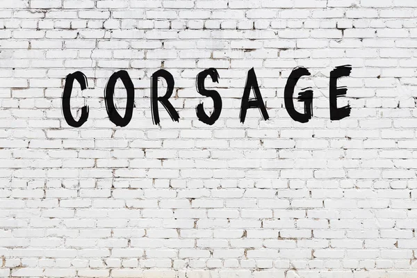 Siyah boyayla el yazısıyla yazılmış beyaz tuğlalı bir duvar.