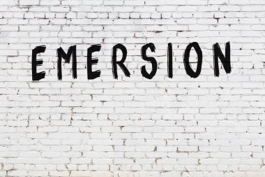 Beyaz tuğla duvara siyah boya ile yazılmış bir yazı..