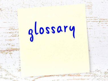 Sözlükle ilgili hatırlatma kavramı. Tahta duvarda üzerinde yazı olan sarı yapışkan kağıt.